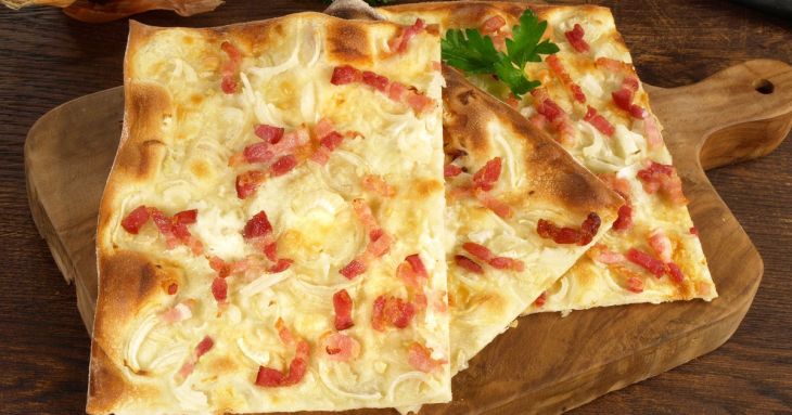 A vékony tésztájú német pizza receptje: tejfölös alapra kerül a többi feltét