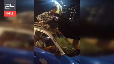 Videón, ahogy egy mumbai férfi egy száguldó autó tetején ül, mert a sofőr nem akar megállni